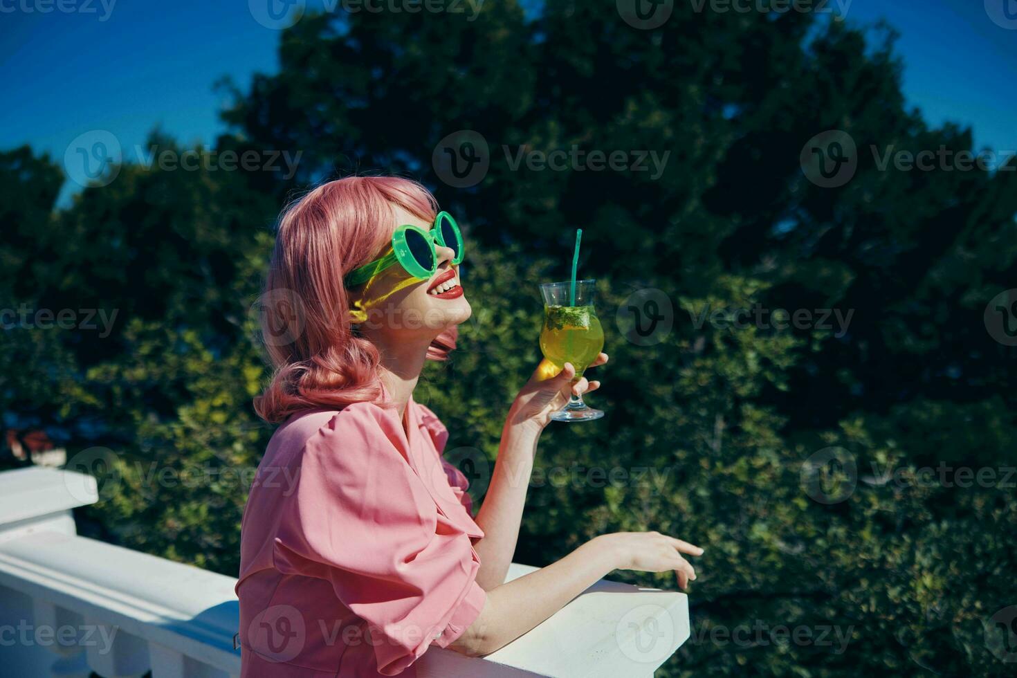 verheugd jong meisje met roze haar- zomer cocktail verfrissend drinken gelukkig vrouw ontspannende foto