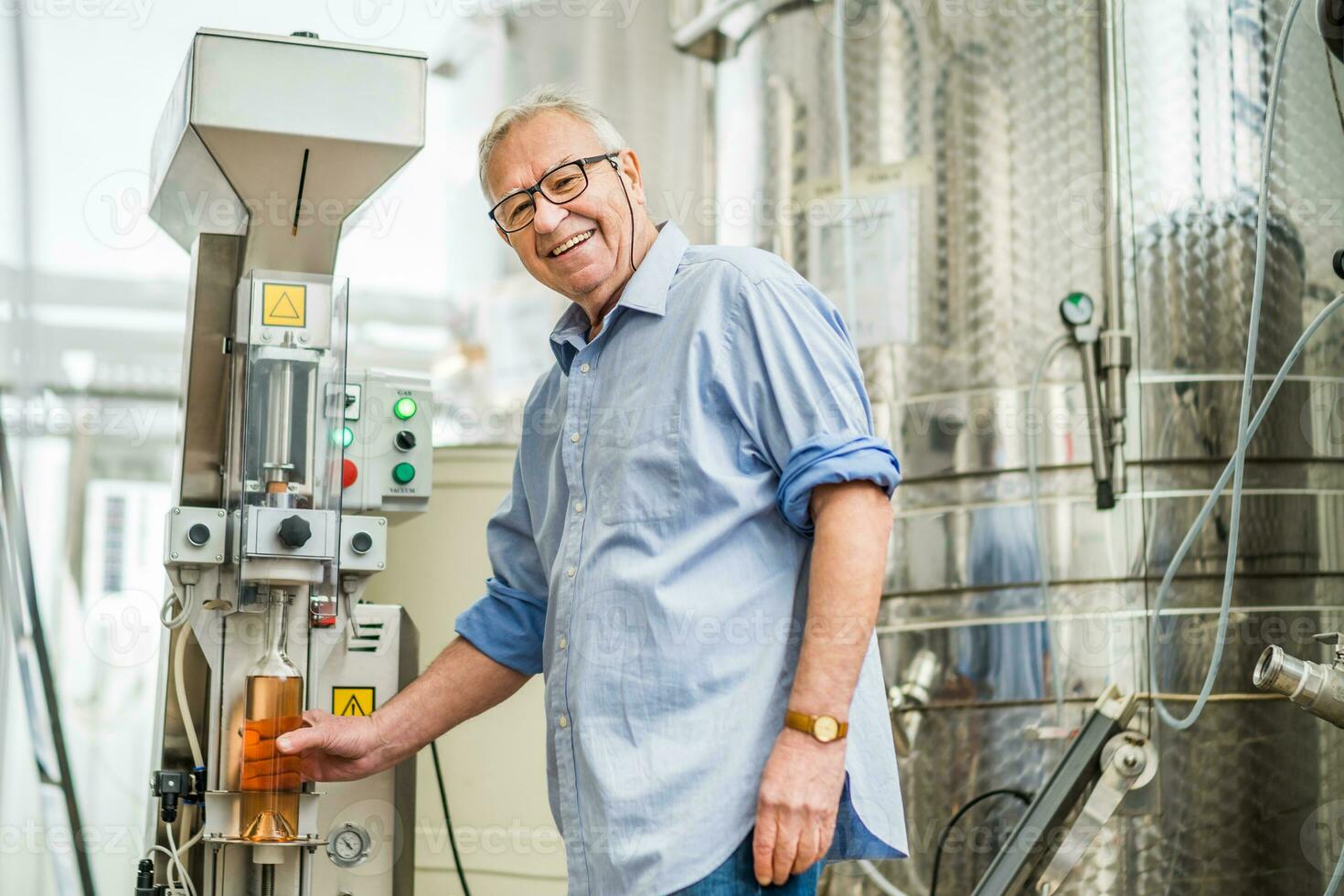 senior Mens in werking een wijn tank in de wijnmakerij foto