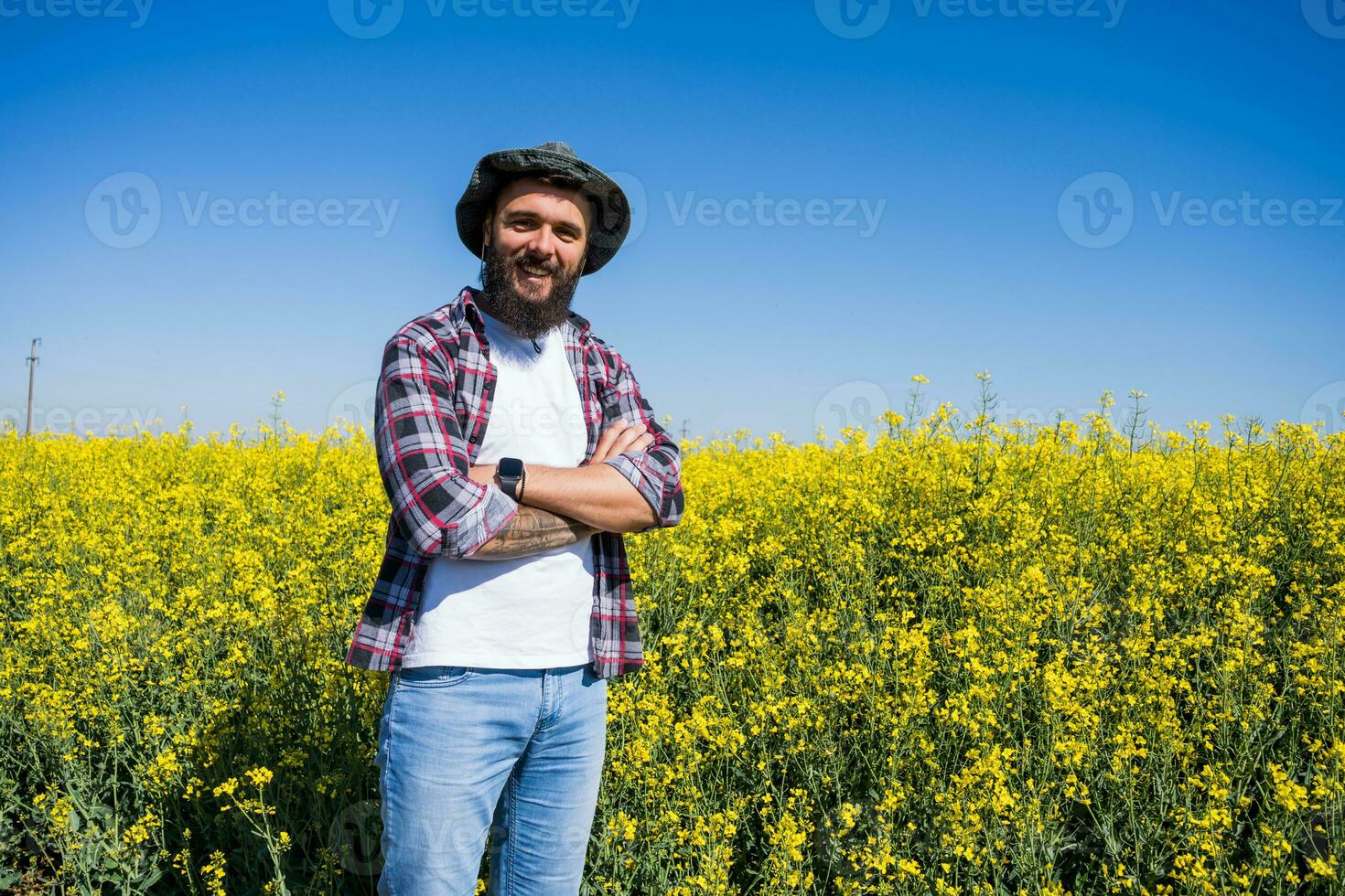 een boer staat in een koolzaad veld- foto