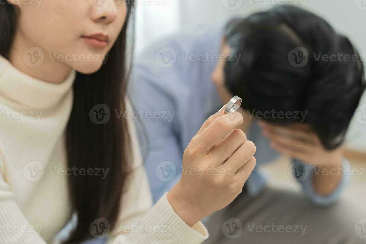 benadrukt Aziatisch jong paar Mens, vrouw ruzie Aan bank, verhouding in probleem. vrouwen hand- Holding bruiloft ring in teleurstelling en van streek haar echtgenoot, welke mei lood naar scheiding. probleem van familie foto