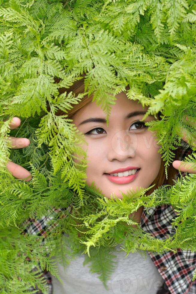 close-up portret van een glimlachend jong mooi meisje met blad foto