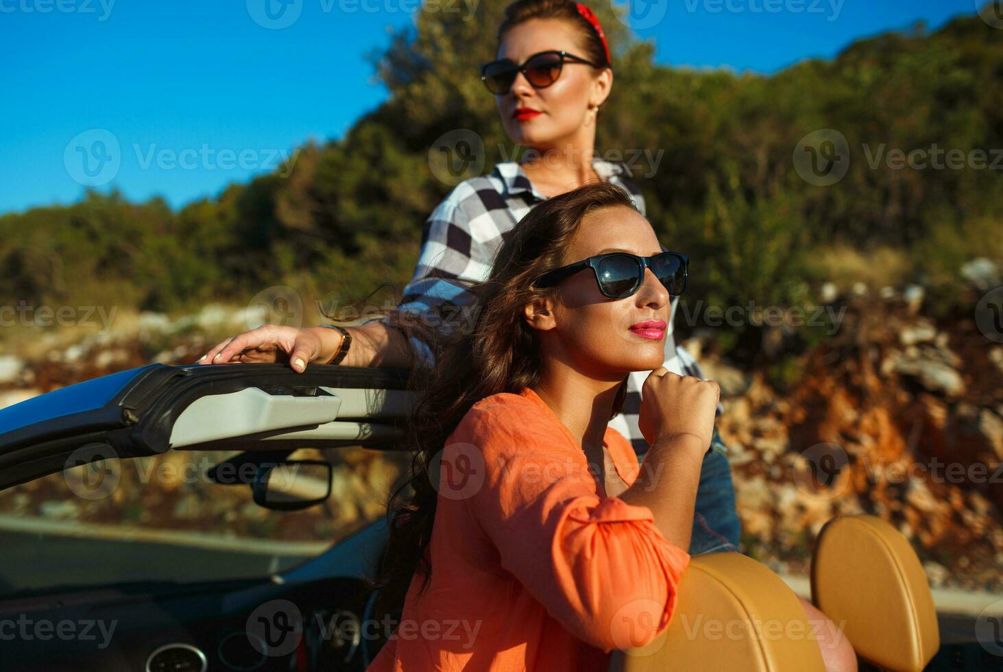 twee jong meisjes hebben pret in de cabriolet buitenshuis foto