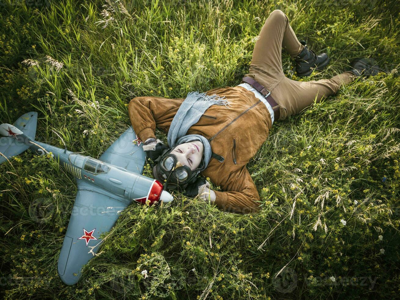 jong vent in wijnoogst kleren piloot met een vliegtuig model- buitenshuis foto