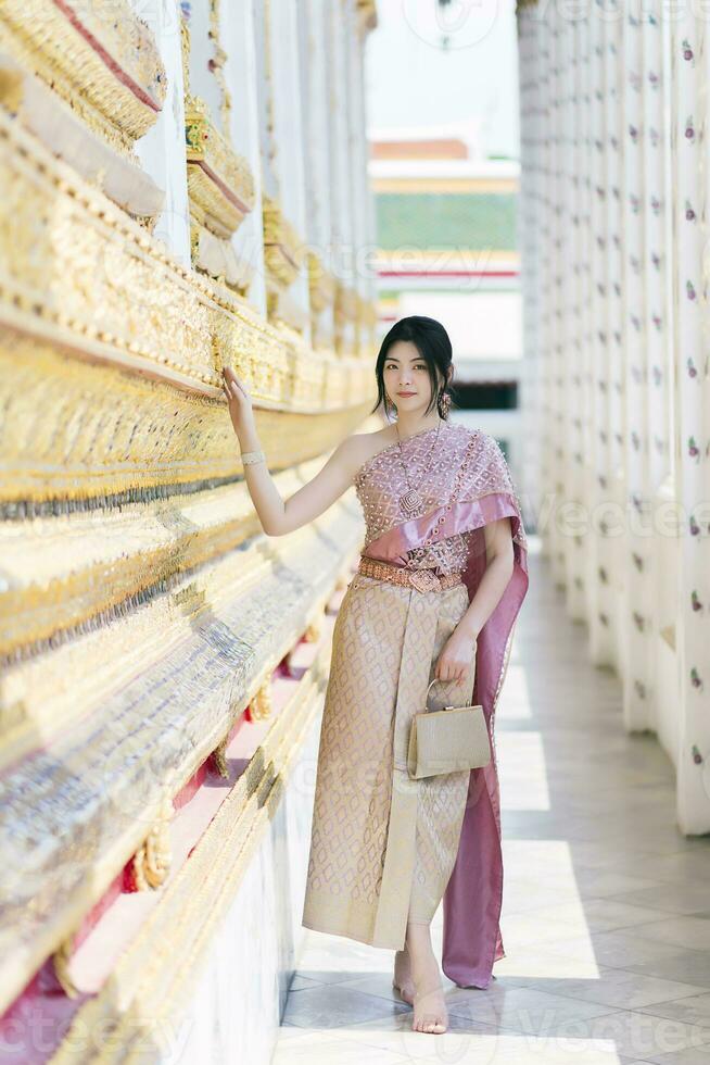 mooi Aziatisch meisje in Thais traditioneel kostuum Bij tempel foto