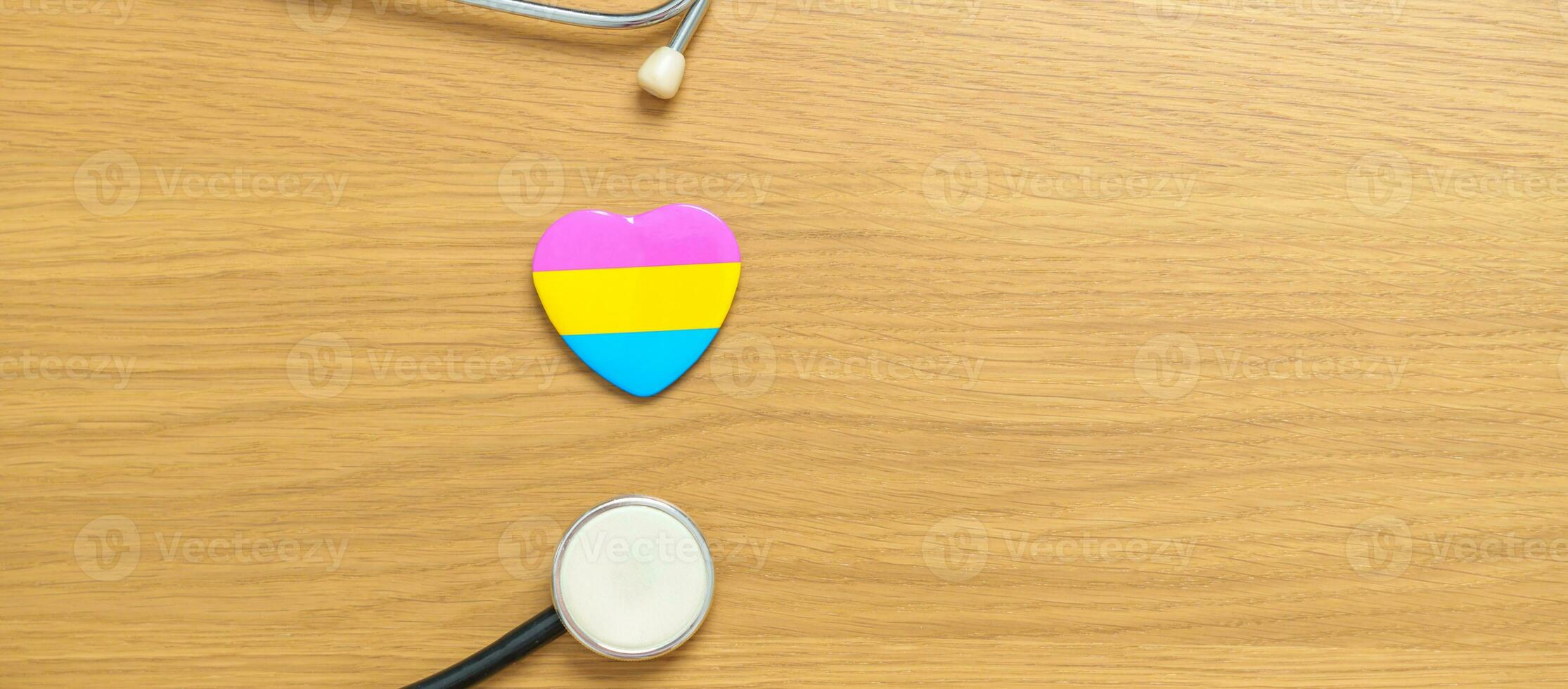 pansexueel trots dag en lgbt trots maand concept. roze, geel en blauw hart vorm met stethoscoop voor lesbienne, homo, biseksueel, transgender, vreemd en pansexueel gemeenschap foto