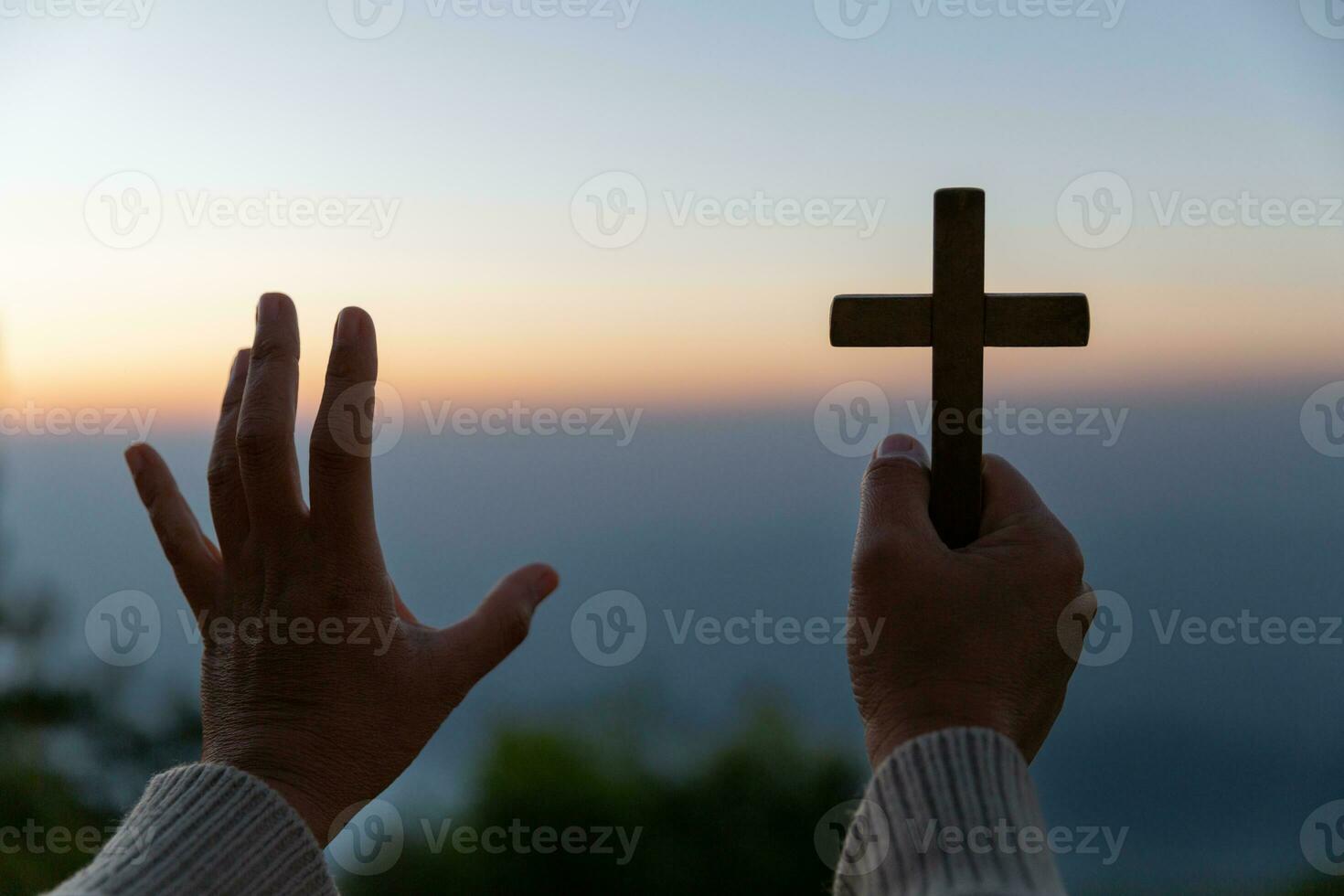 persoon handen palm omhoog bidden en aanbidden van kruis met geloof in Jezus Christus. Eucharistie behandeling god zegent helpen, hoop, en vertrouwen, christen religie concept Aan zonsondergang achtergrond. foto