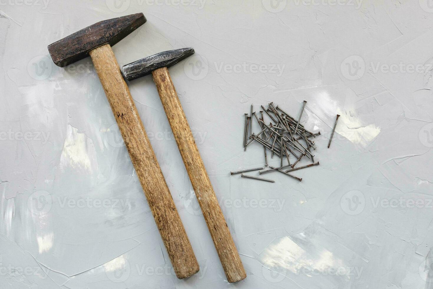 twee hamers en oud roestig nagels Aan grijs achtergrond foto