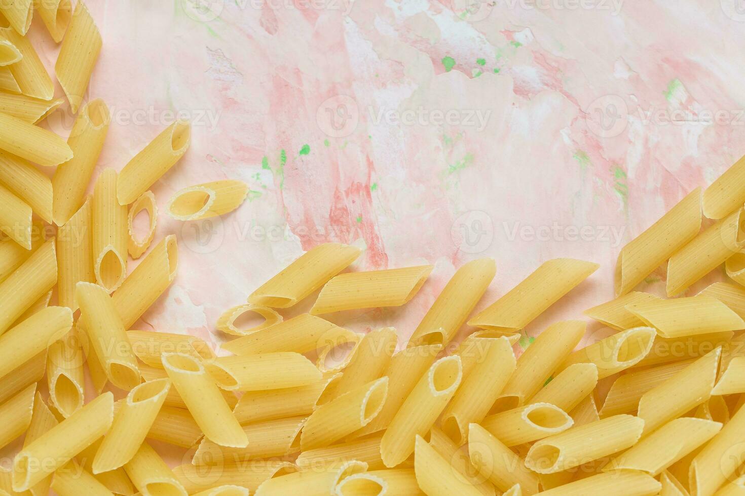 rauw Italiaans penne pasta Aan roze achtergrond foto