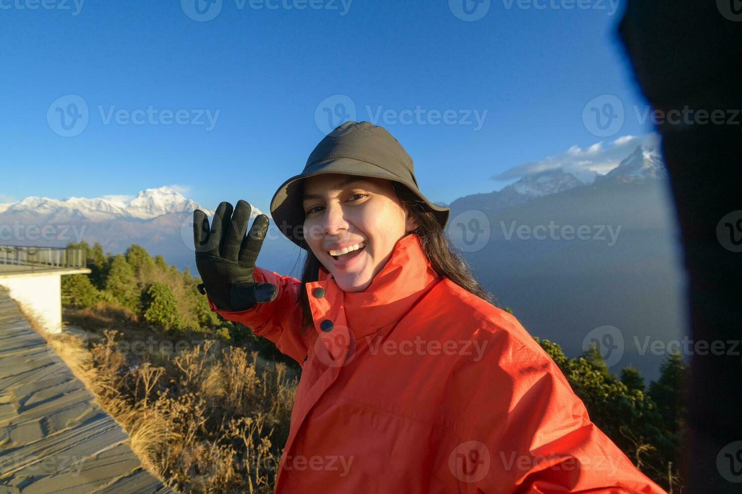 een jong reiziger duurt een selfie of een video telefoontje terwijl staand een top een berg. foto