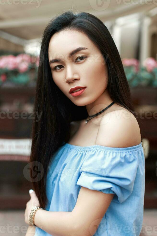 portret van een mooi Vietnamees vrouw met kaal schouders Aan stedelijk achtergrond foto