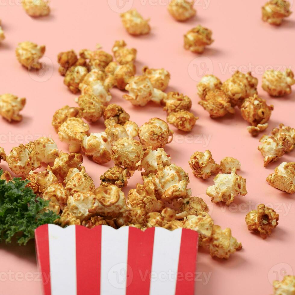 streep doos met popcorn Aan roze achtergrond foto