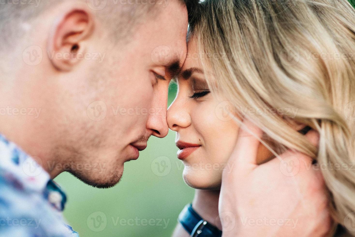 blond meisje met losse haren in een lichtblauwe jurk en een jongen in het licht van de zonsondergang foto