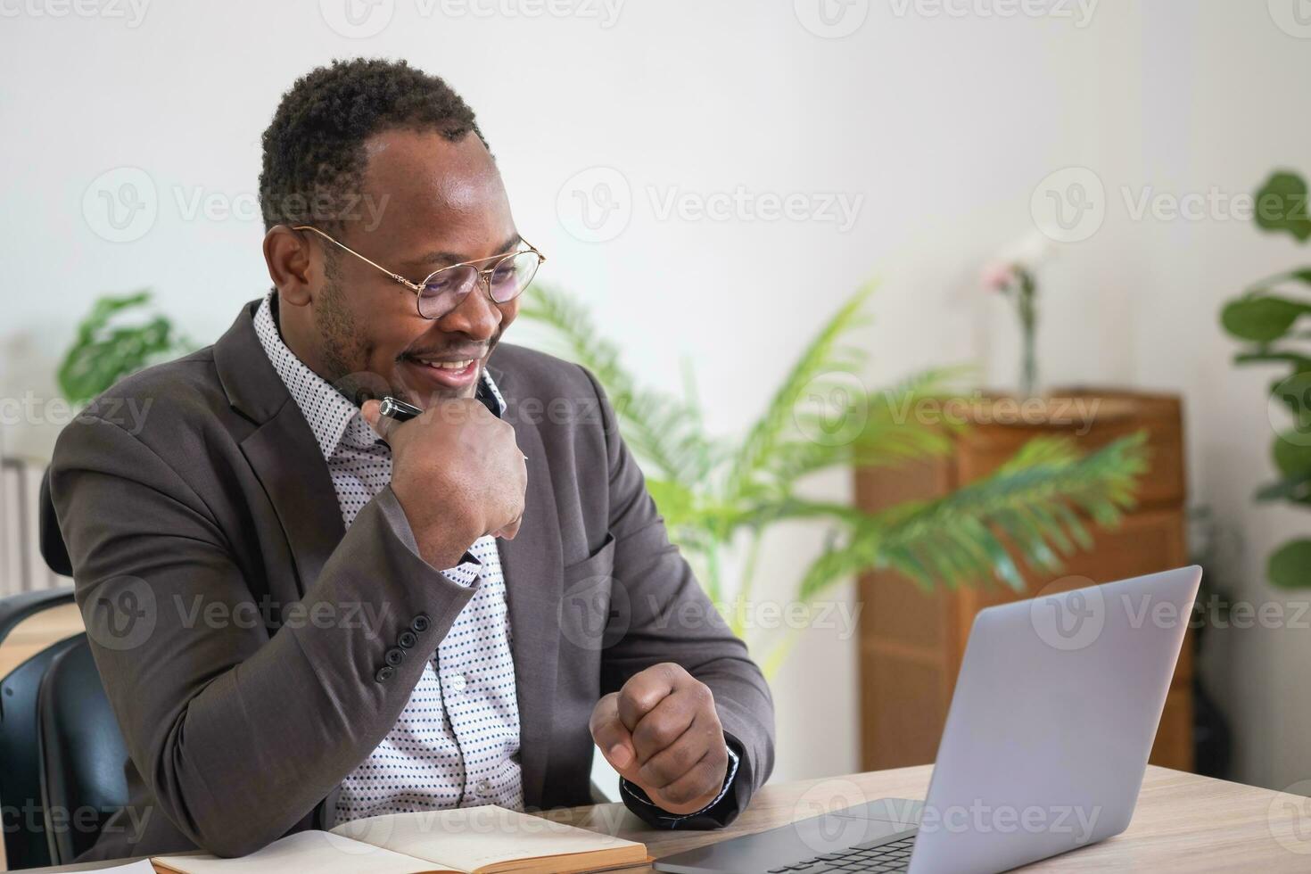 Afrikaanse Amerikaans zakenman analyseren laptop diagram papierwerk in kantoor Holding documenten voorbereidingen treffen portefeuille analyse verslag doen van zwart mannetje analist aan het doen papierwerk in de werkplaats gebruik makend van de computer. foto