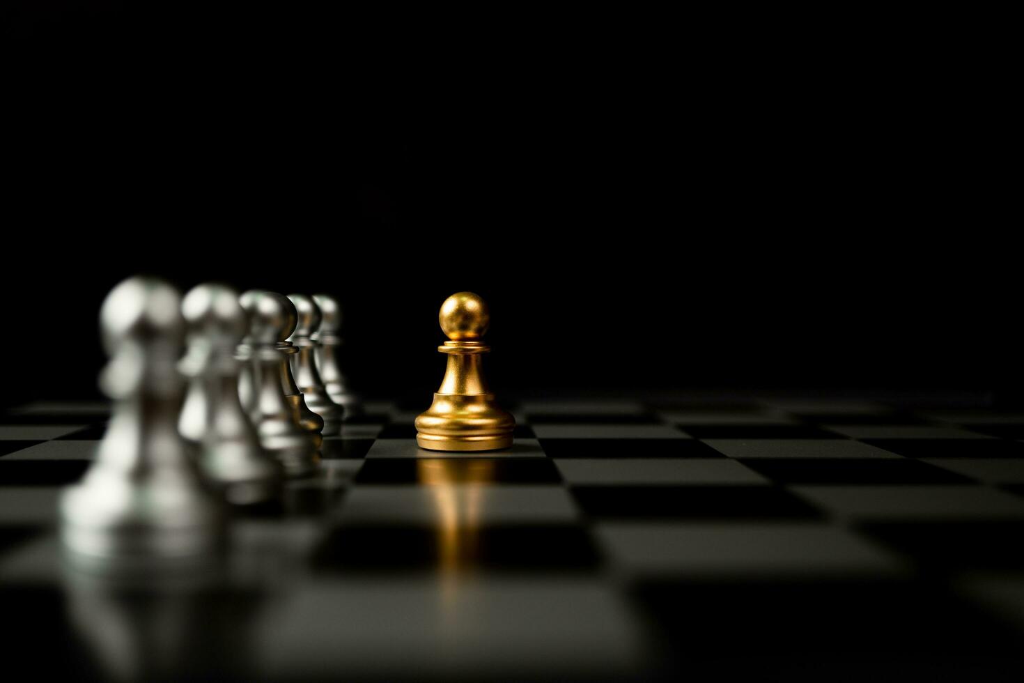 gouden schaakpion die voor ander schaak staat, het concept van een leider moet moed en uitdaging hebben in de competitie, leiderschap en zakelijke visie voor een overwinning in zakelijke games foto