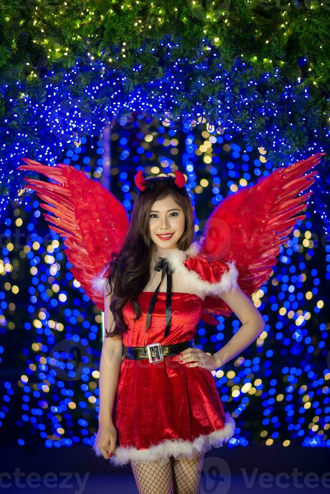 mooi Aziatisch meisje in de kerstman kostuum voor Kerstmis met nacht licht foto