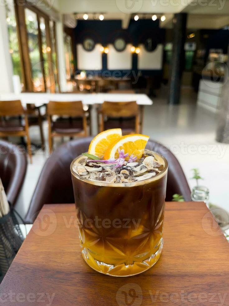 een glas van bevroren americano zwart koffie en laag van oranje foto