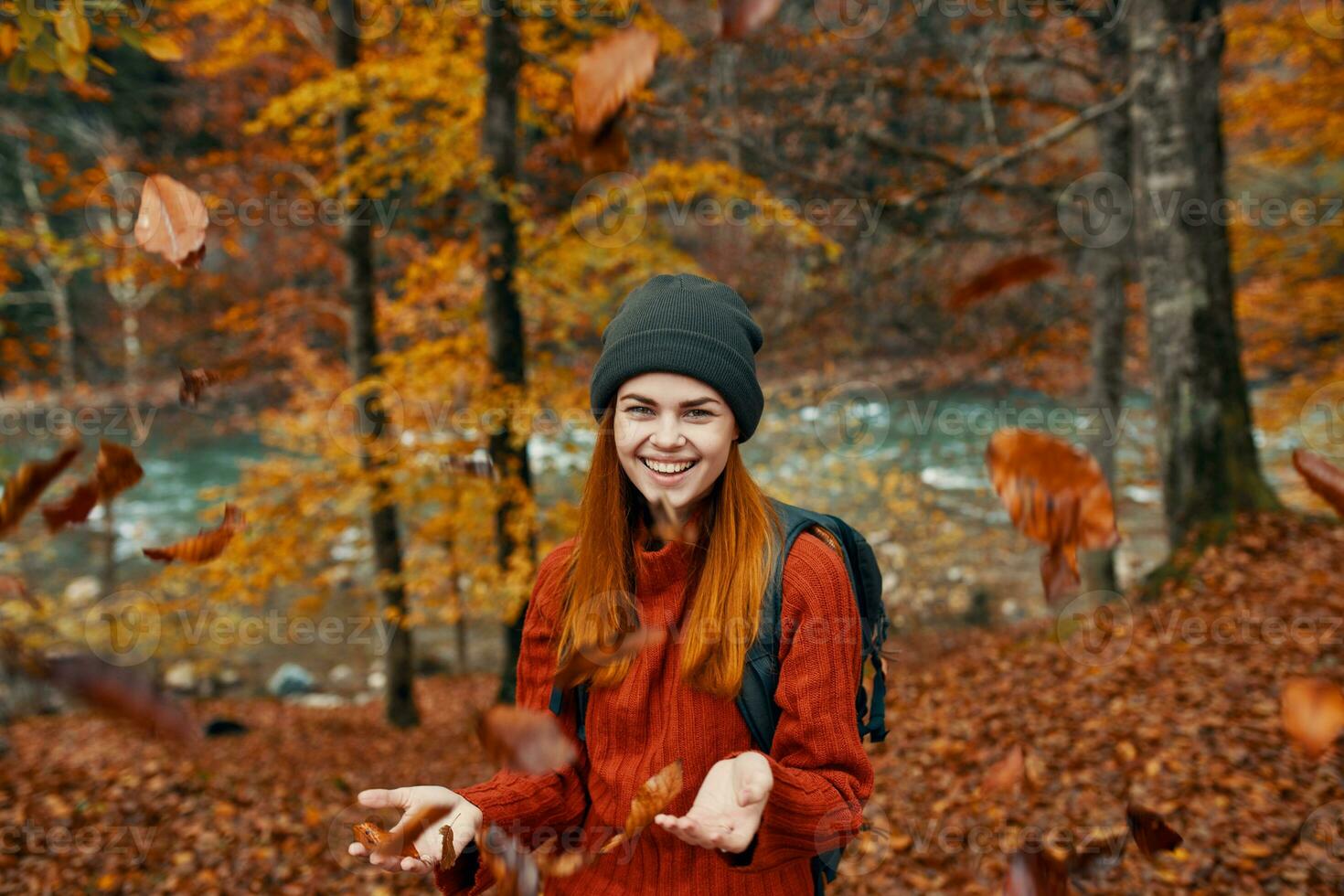 vrolijk vrouw reist in de herfst Woud in natuur in de buurt de rivier- en hoog bomen in de achtergrond foto