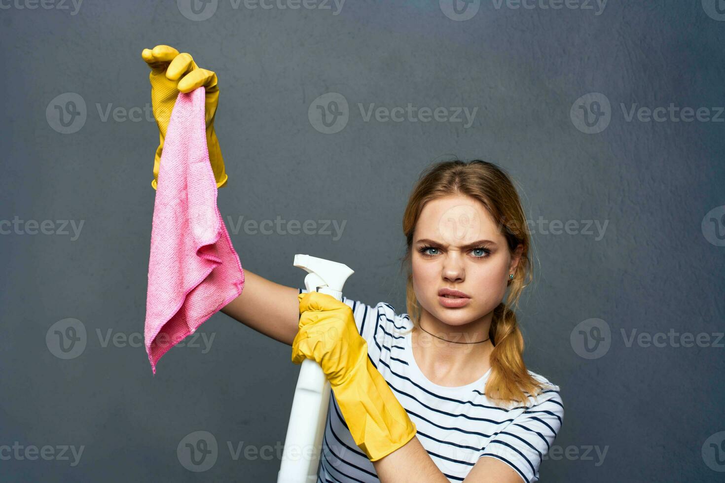 schoonmaak dame met roze vod in hand- huis zorg onderhoud grijs achtergrond foto