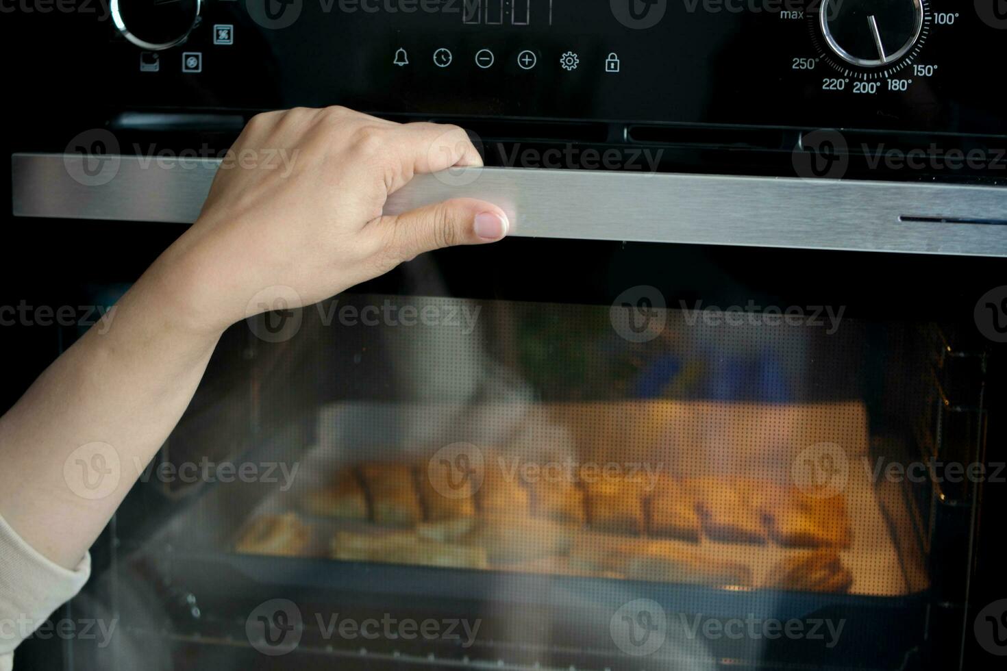 bijgesneden visie van hand- Open deur Bij zilver gas- oven. foto