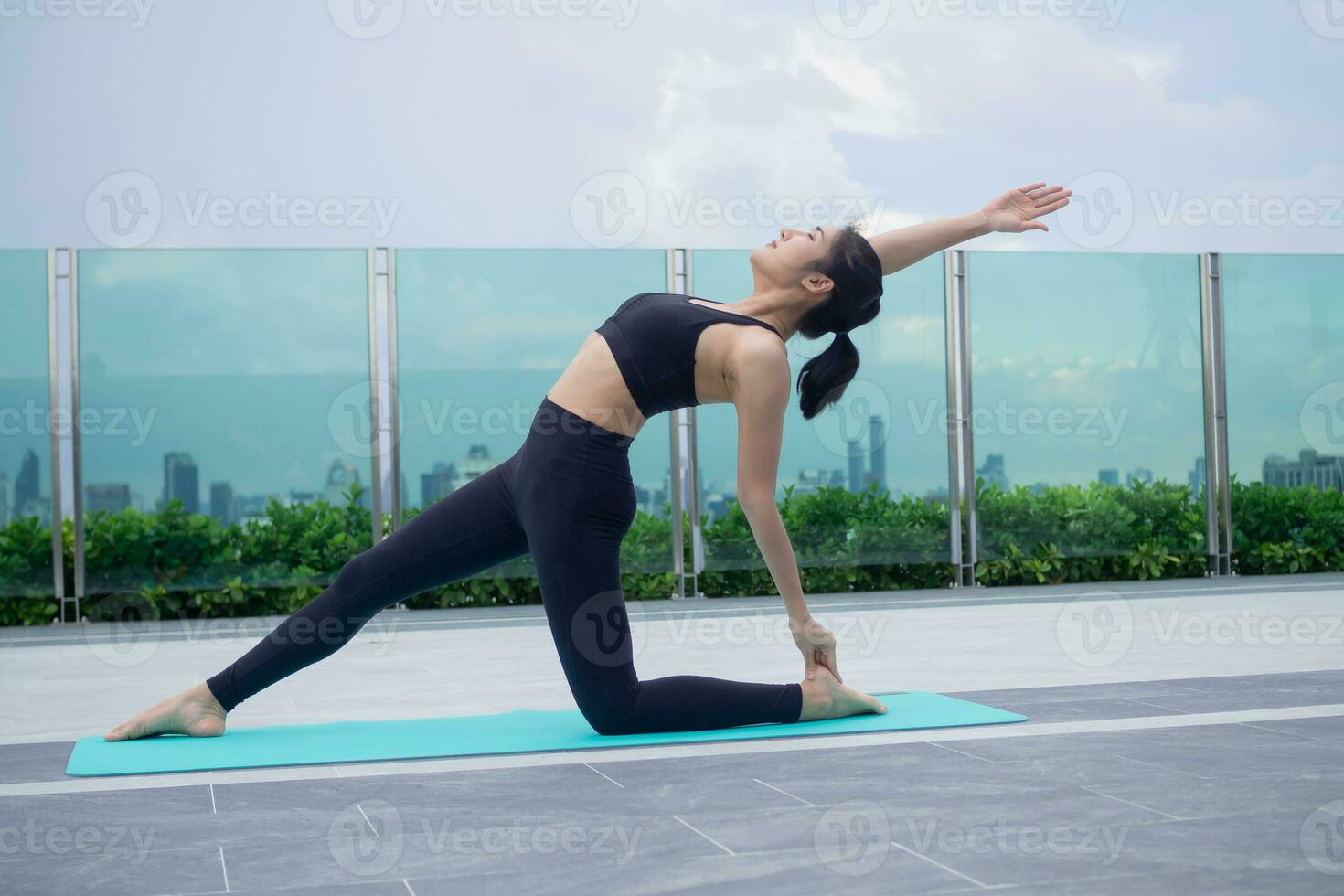 slank vrouw beoefenen yoga Aan de balkon van haar appartement. Aziatisch vrouw aan het doen opdrachten in ochtend. evenwicht, meditatie, ontspanning, kalm, mooi zo Gezondheid, Vrolijk, kom tot rust, gezond levensstijl concept foto