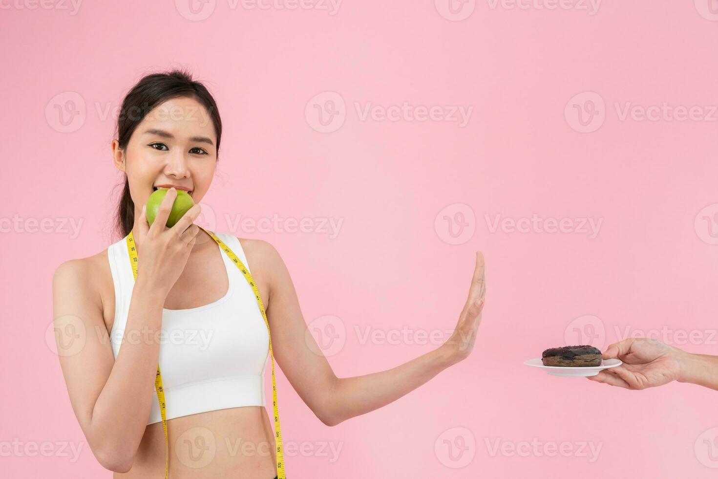 slank lichaam Dames Kiezen gedurende groen appel en chocola donut, vrouw Kiezen groen appel voor eetpatroon. mooi zo gezond voedsel. gewicht verliezen, evenwicht, controle, verminderen dik, laag calorieën, routines, oefening. foto