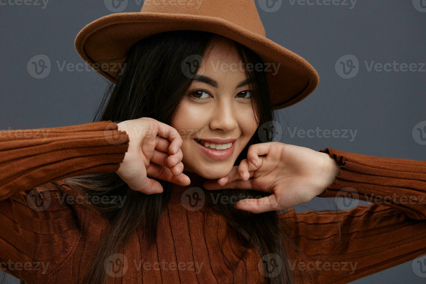 portret vrouw in hoed pret bruin trui poseren gewoontjes slijtage grijs achtergrond foto