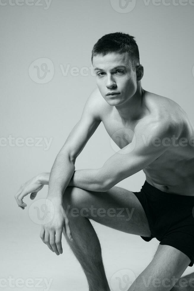 grijs foto van atleet in zwart slipje naakt torso bodybuilder