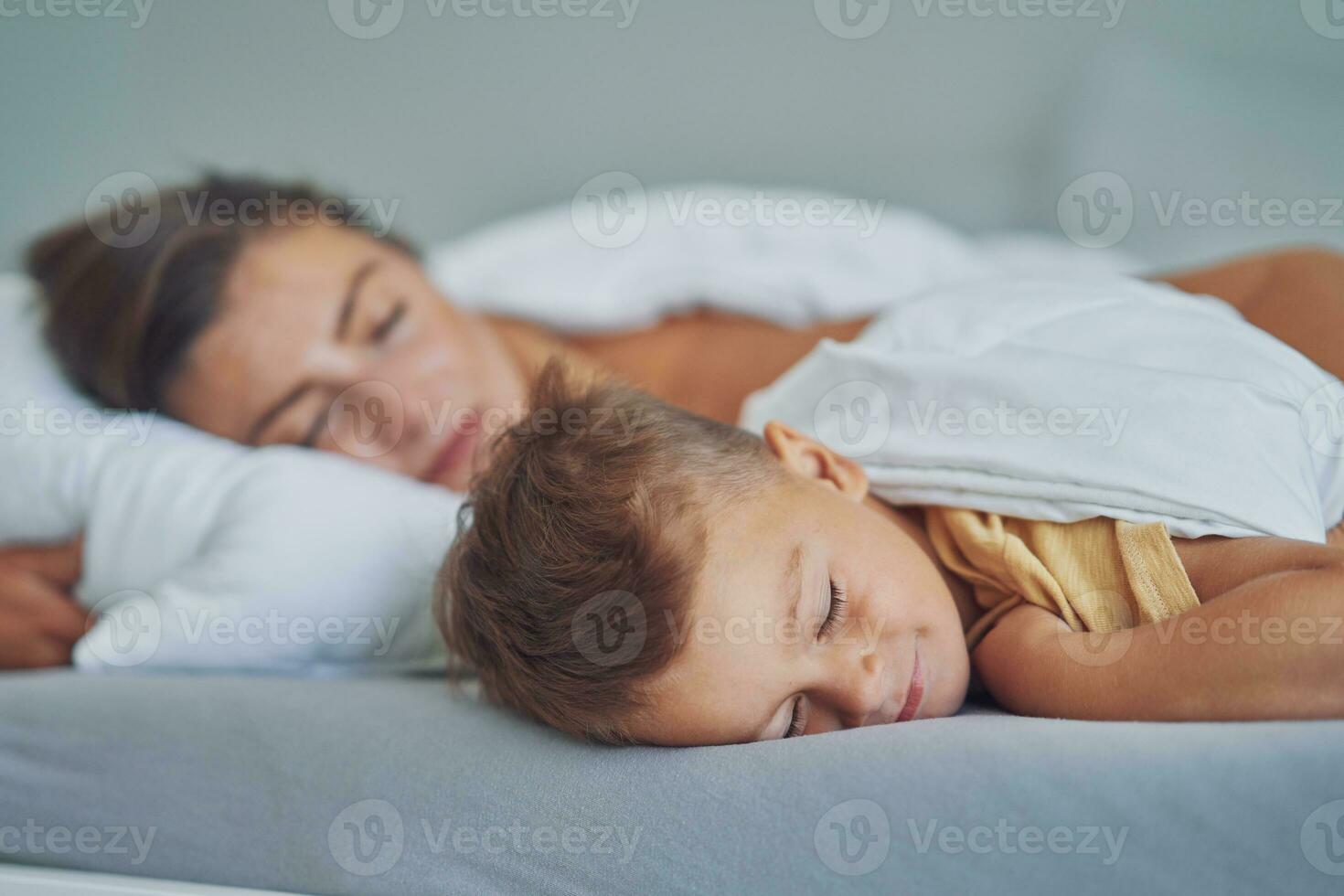 jong moeder met 4 jaren oud zoon in bed foto