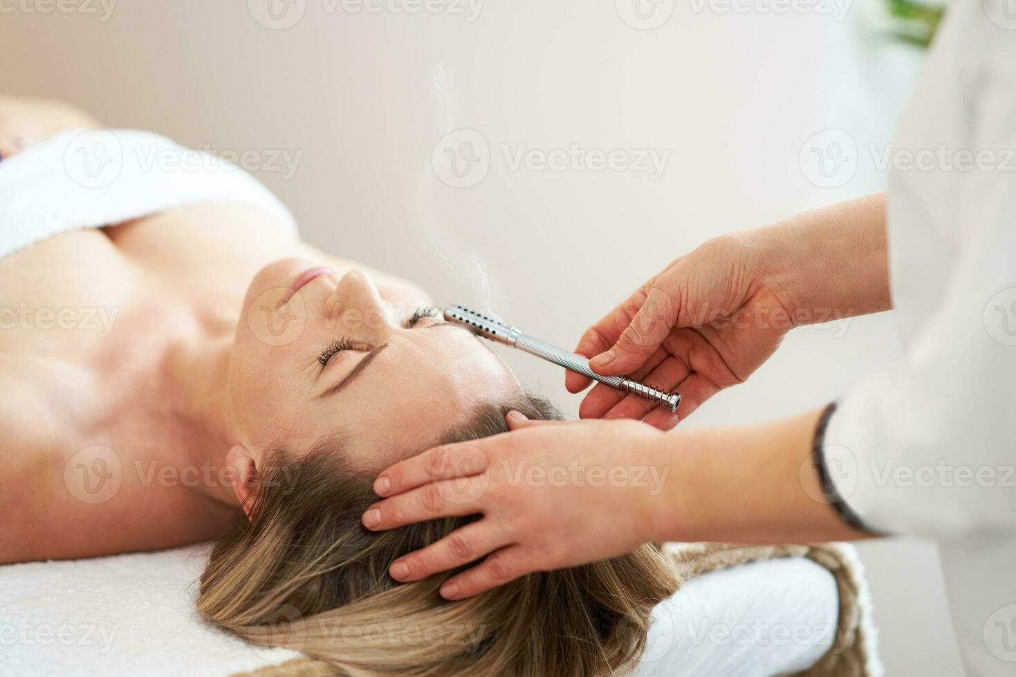 afbeelding van moxibustie rol behandeling op vrouw gezicht foto