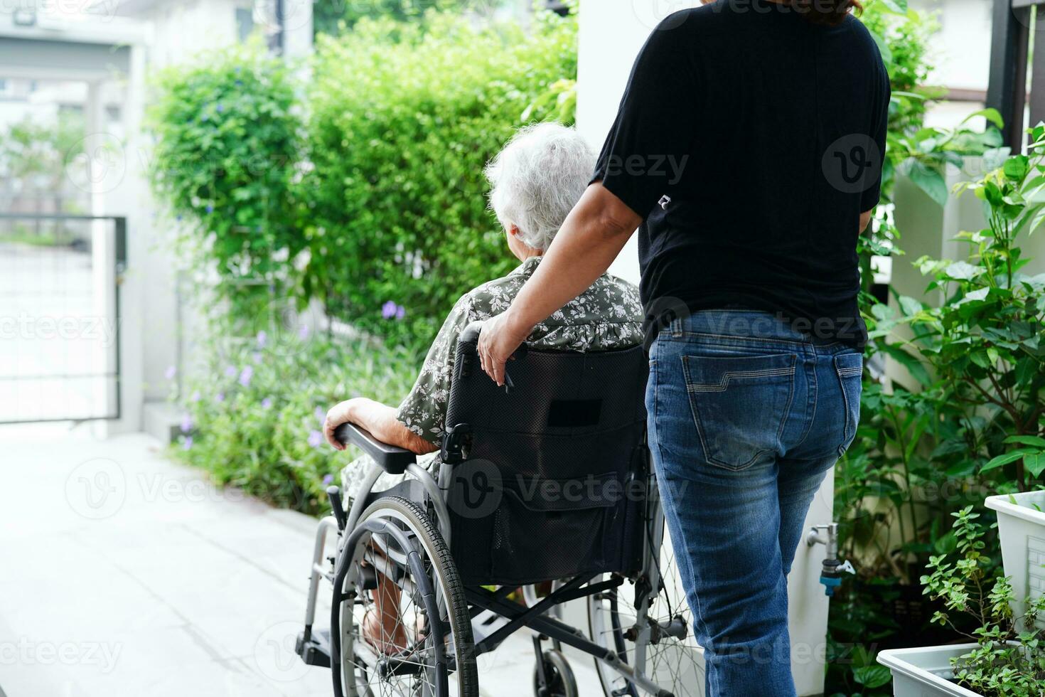 verzorger helpen Aziatisch ouderen vrouw onbekwaamheid geduldig zittend Aan rolstoel in ziekenhuis, medisch concept. foto