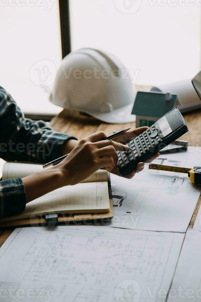 twee specialisten inspecteren reclame, industrieel gebouw bouw plaats. echt landgoed project met civiel ingenieur, investeerder gebruik laptop. in de achtergrond kraan, wolkenkrabber beton bekisting kaders foto