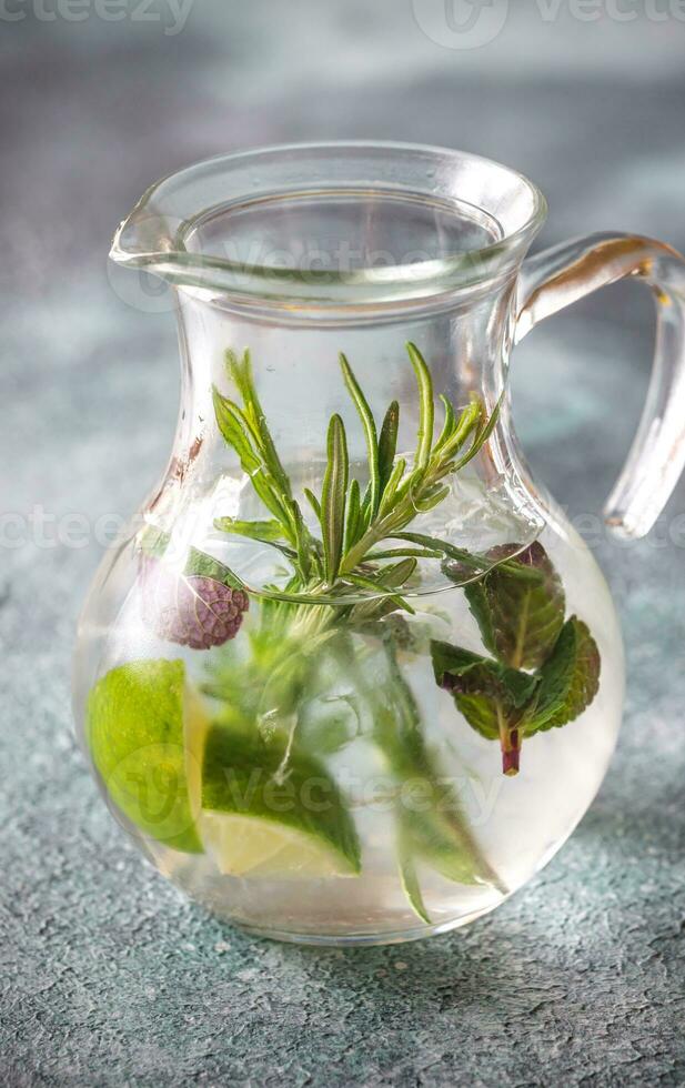 glas pot van limoen water met kruiden foto