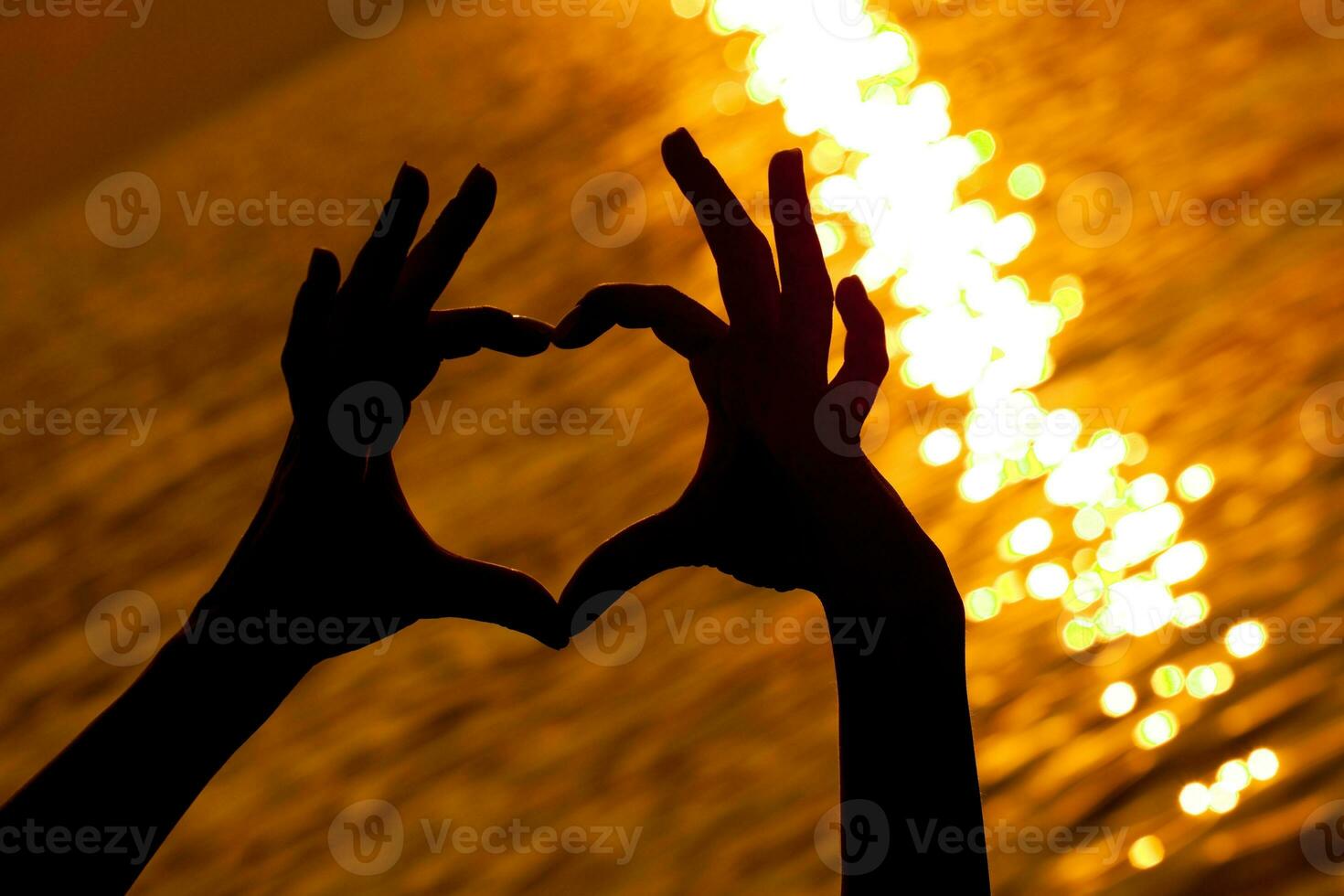 handen met hart vorm over- de zonsondergang foto