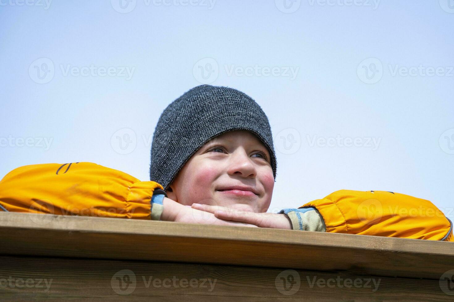 portret jongen in een oranje jasje . de jongen looks in de afstand foto