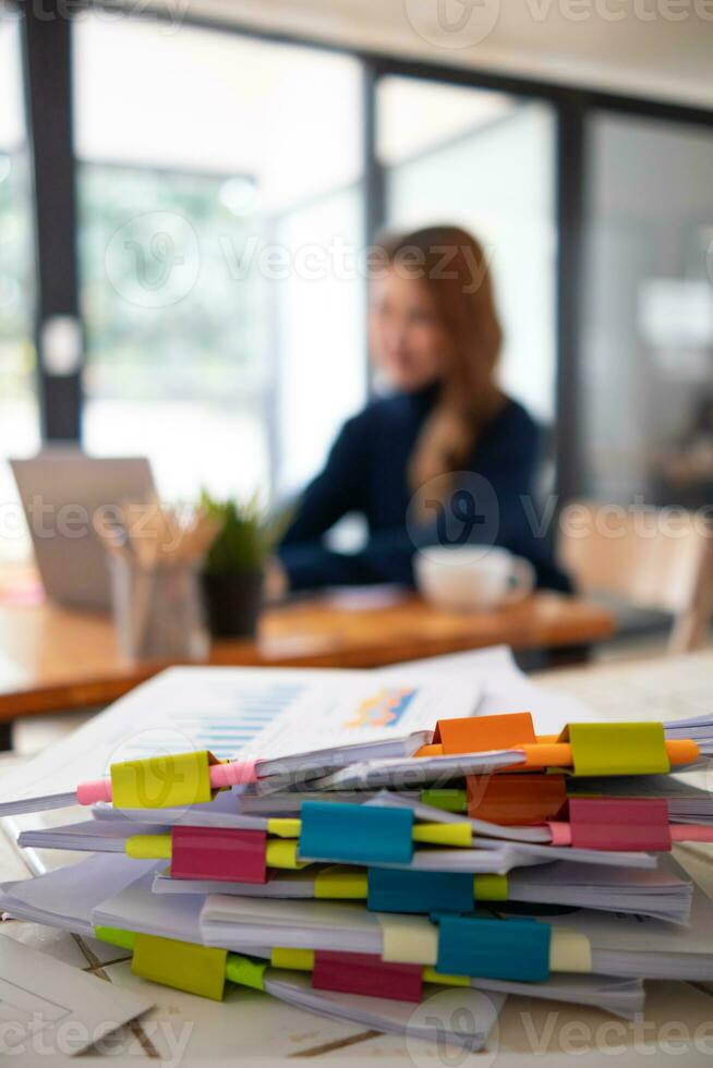 zakenvrouw handen werken Aan stapels van papier documenten naar zoeken en recensie documenten opgestapeld Aan tafel voordat Bezig met verzenden hen naar bord van bestuurders naar gebruik correct documenten in vergadering met zakenman foto