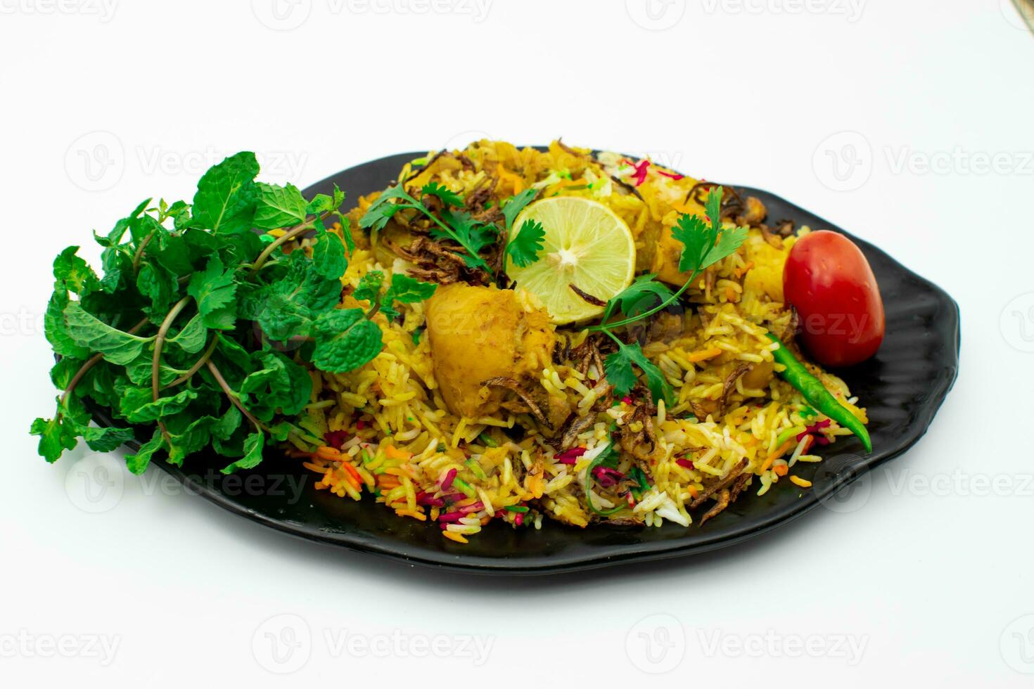 geïsoleerd heerlijk pittig kip biryani in zwart bord Aan wit achtergrond foto