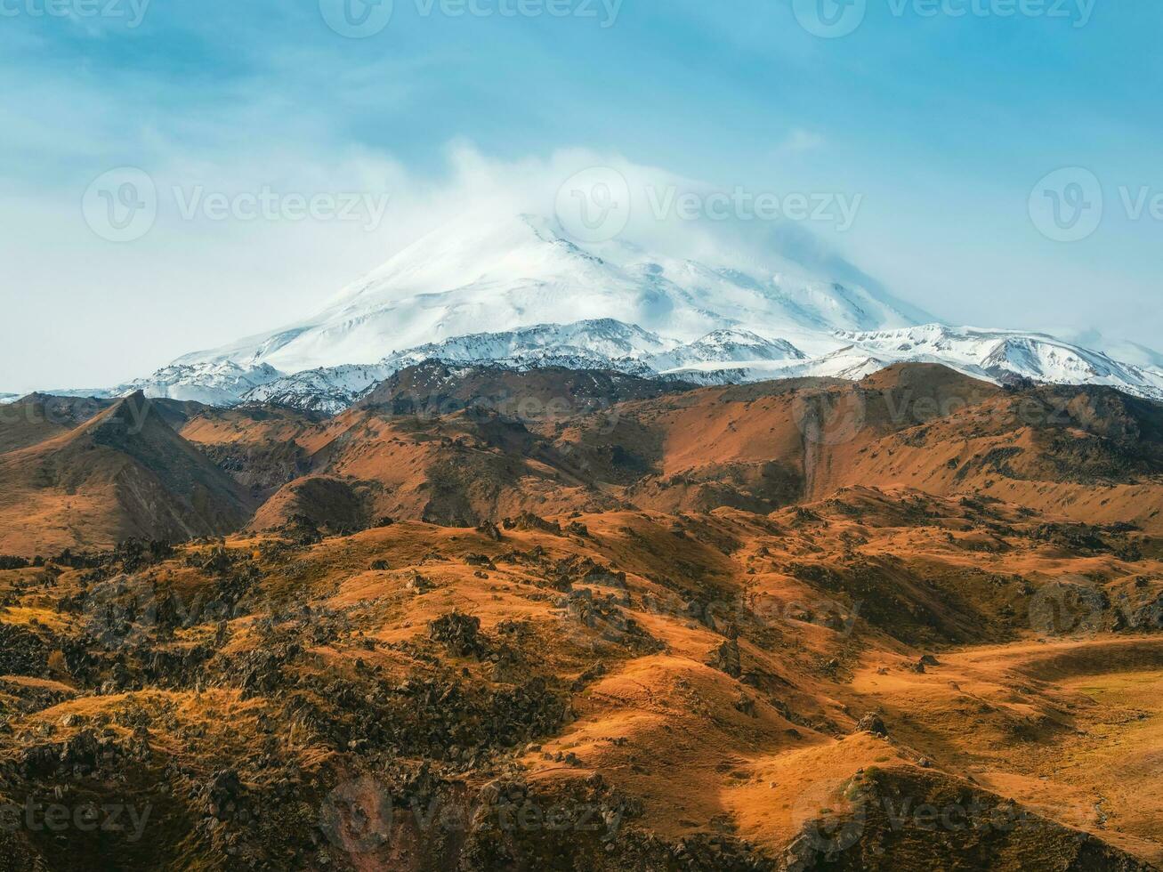 helder wit besneeuwd top van monteren elbrus bovenstaand de herfst rotsachtig plateau. herfst elbroes. herfst in de Kaukasus bergen. wit sneeuw groot bergen. sneeuw pieken. foto