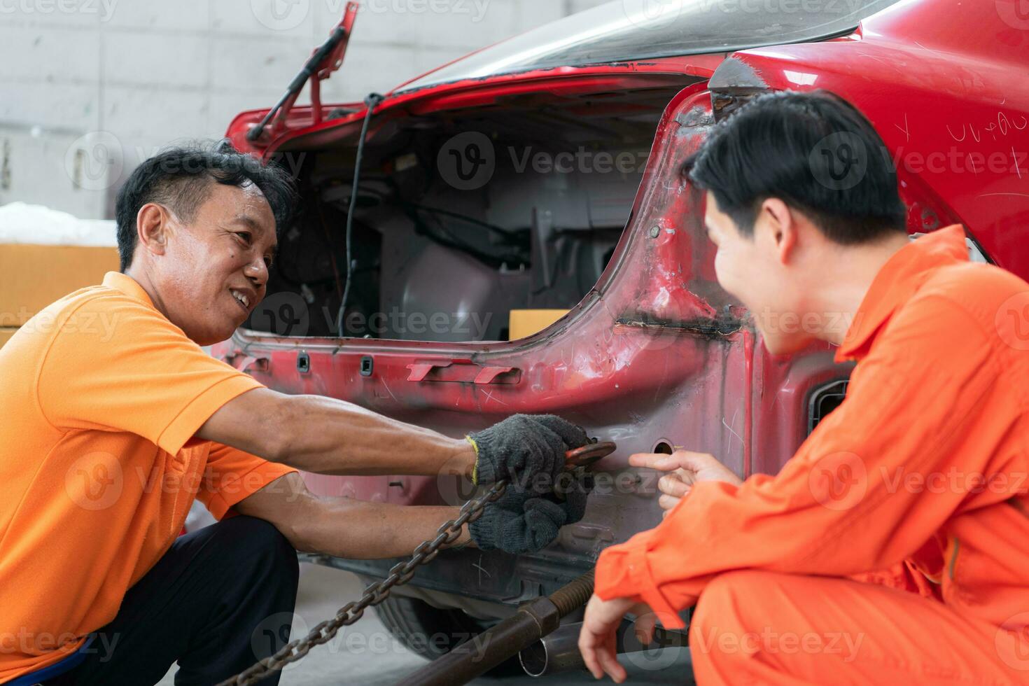 naar terugkeer de auto- lichaam naar haar voormalig vorm geven aan, een auto reparatie monteur toepassingen een machine naar Trekken de auto lichaam veroorzaakt door een zwaar botsing tot het is vervormd. foto