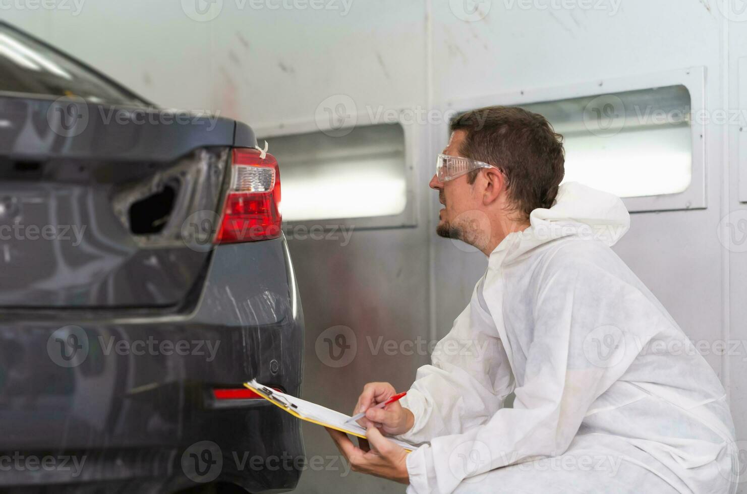 auto monteur klusjesman met een controlelijst, de monteur Mens schilderij auto in kamer, garage schilderij auto onderhoud reparatie en onderhoud foto