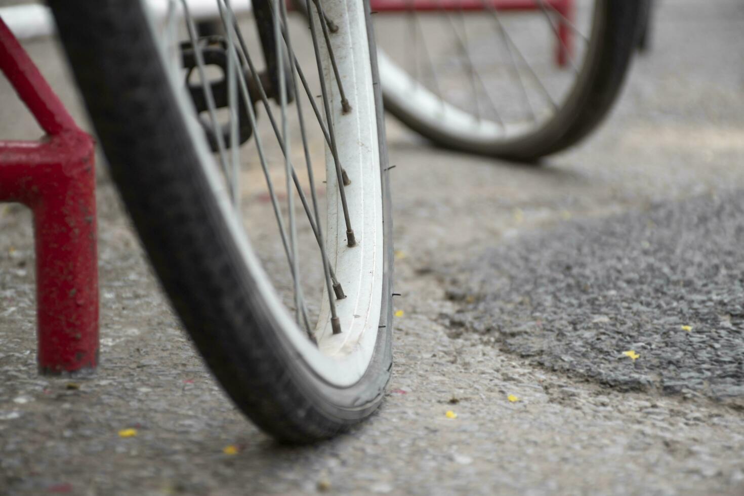 detailopname visie van wijnoogst fiets welke heeft vlak wielen en geparkeerd Aan cement verdieping van straat in de buurt de gebouw, zacht focus. foto