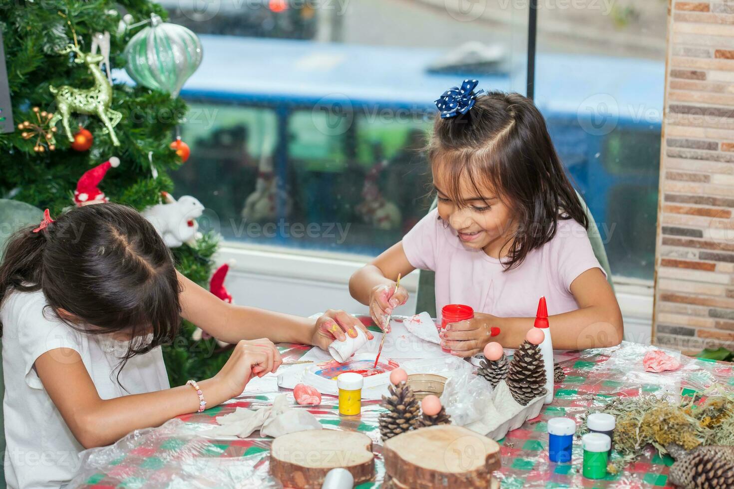 twee weinig zussen hebben pret terwijl maken Kerstmis geboorte ambachten met Bij huis - echt familie foto