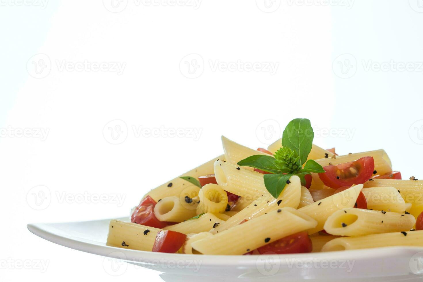 penne rigeren met kers tomaten en zwart peper foto