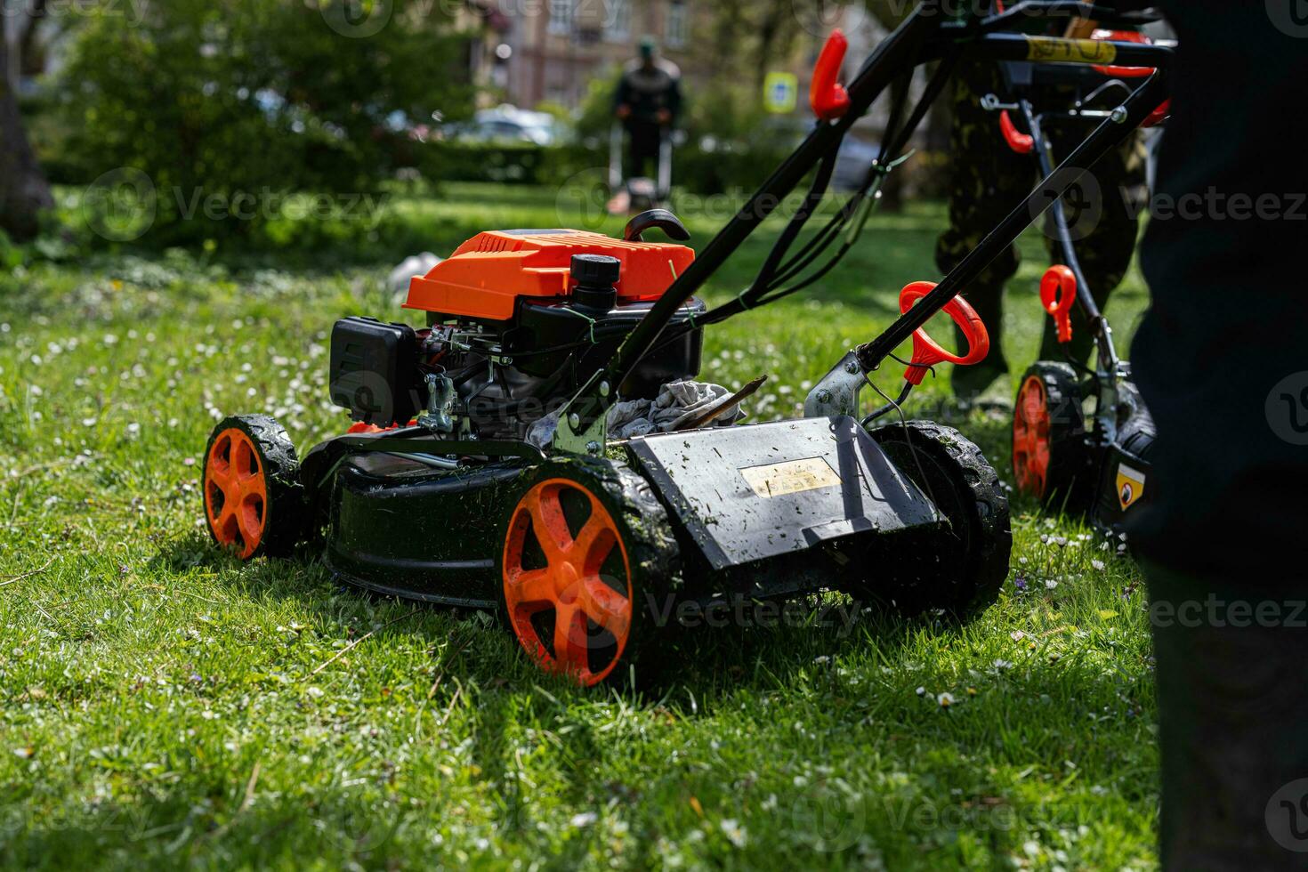 gemeenschappelijk Diensten tuinman arbeiders Mens gebruik makend van gazon maaier voor gras snijdend in stad park. foto