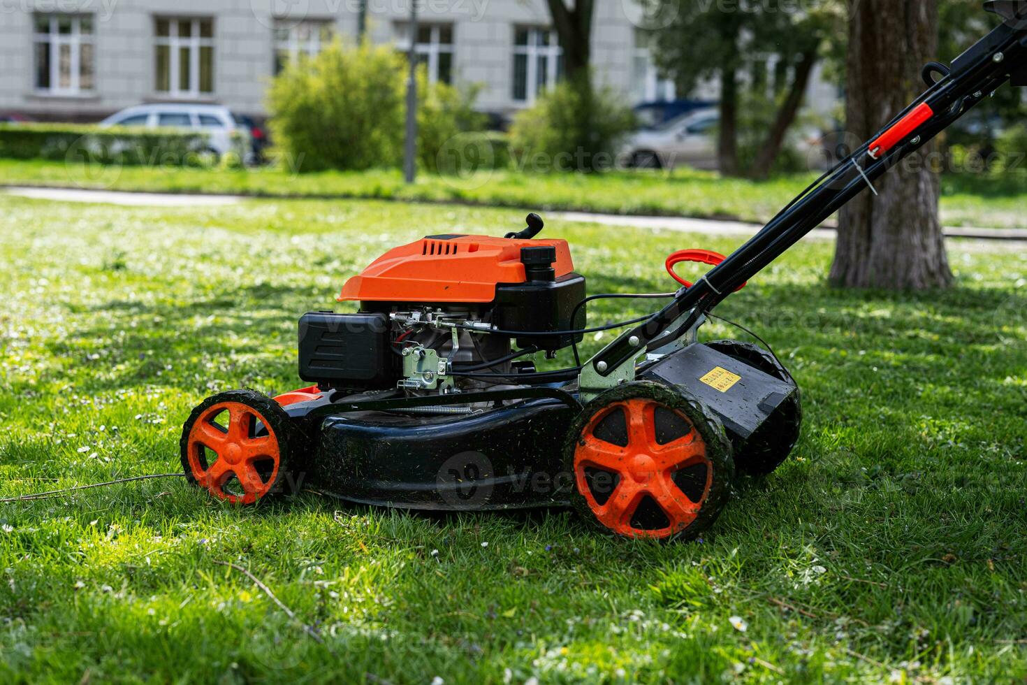 gemeenschappelijk Diensten tuinman arbeider Mens gebruik makend van gazon maaier voor gras snijdend in stad park. foto