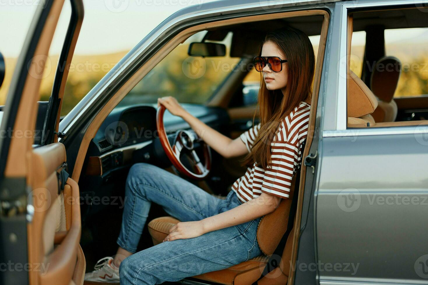 een vrouw bestuurder in zonnebril gestopt de auto Aan de weg in een pktkshestvie en is resting op zoek Bij een mooi visie foto