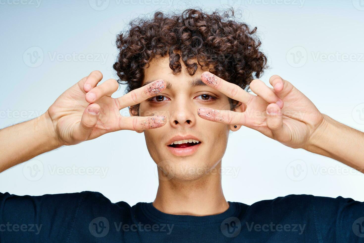 knap Mens met gekruld haar- zwart schoonheidsmiddelen hand- gebaar foto