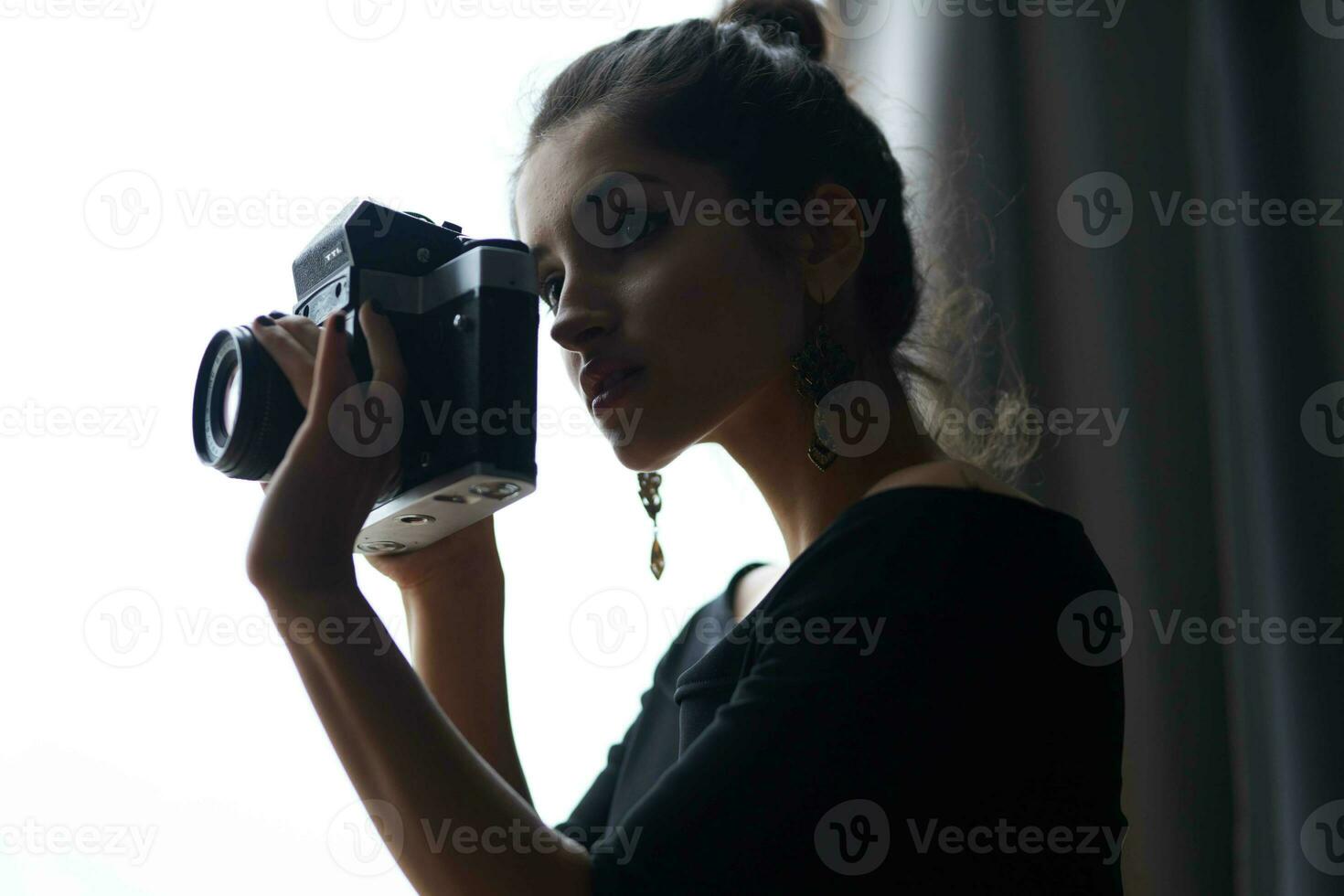 mooi vrouw Holding een camera in de buurt de venster decoratie mode levensstijl studio foto