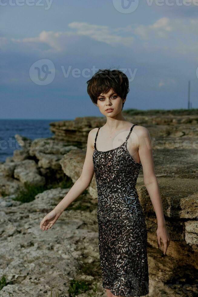 mooi vrouw in jurk Aan natuur rotsen landschap elegantie foto