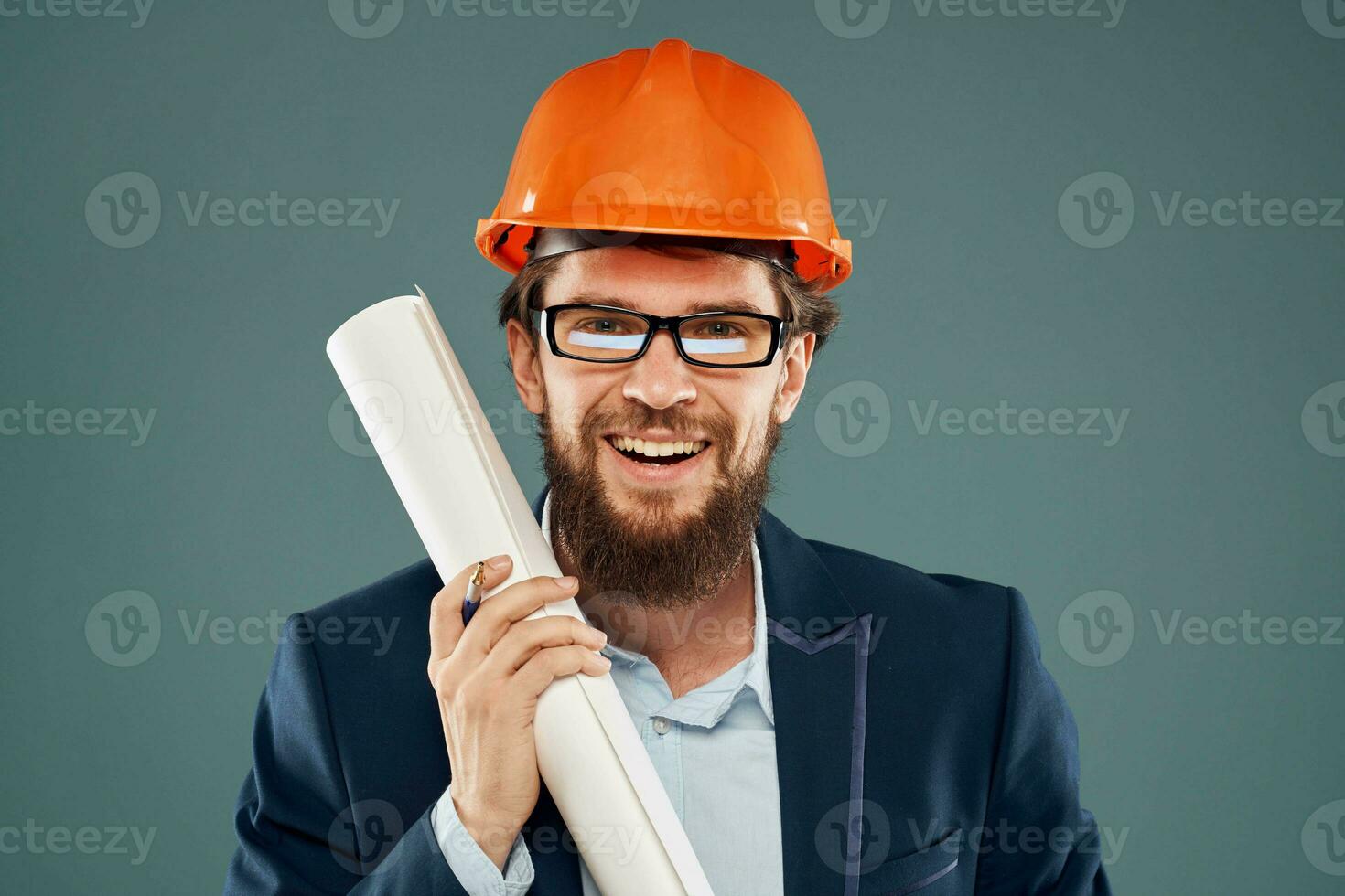 vrolijk Mens met blauwdrukken in handen in oranje helm veiligheid ingenieur bijgesneden visie foto