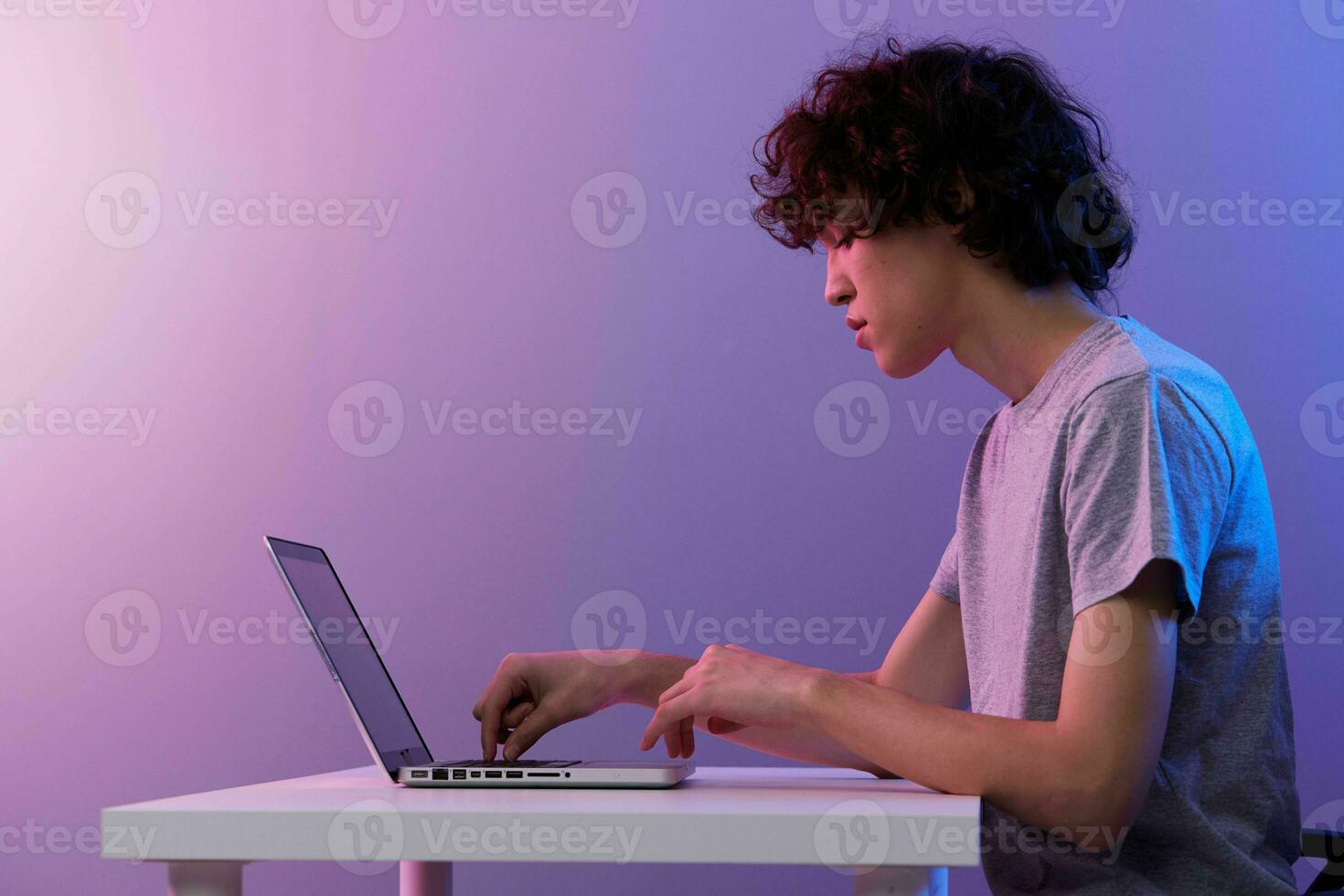 Mens cyberspace spelen met in voorkant van een laptop paars achtergrond foto